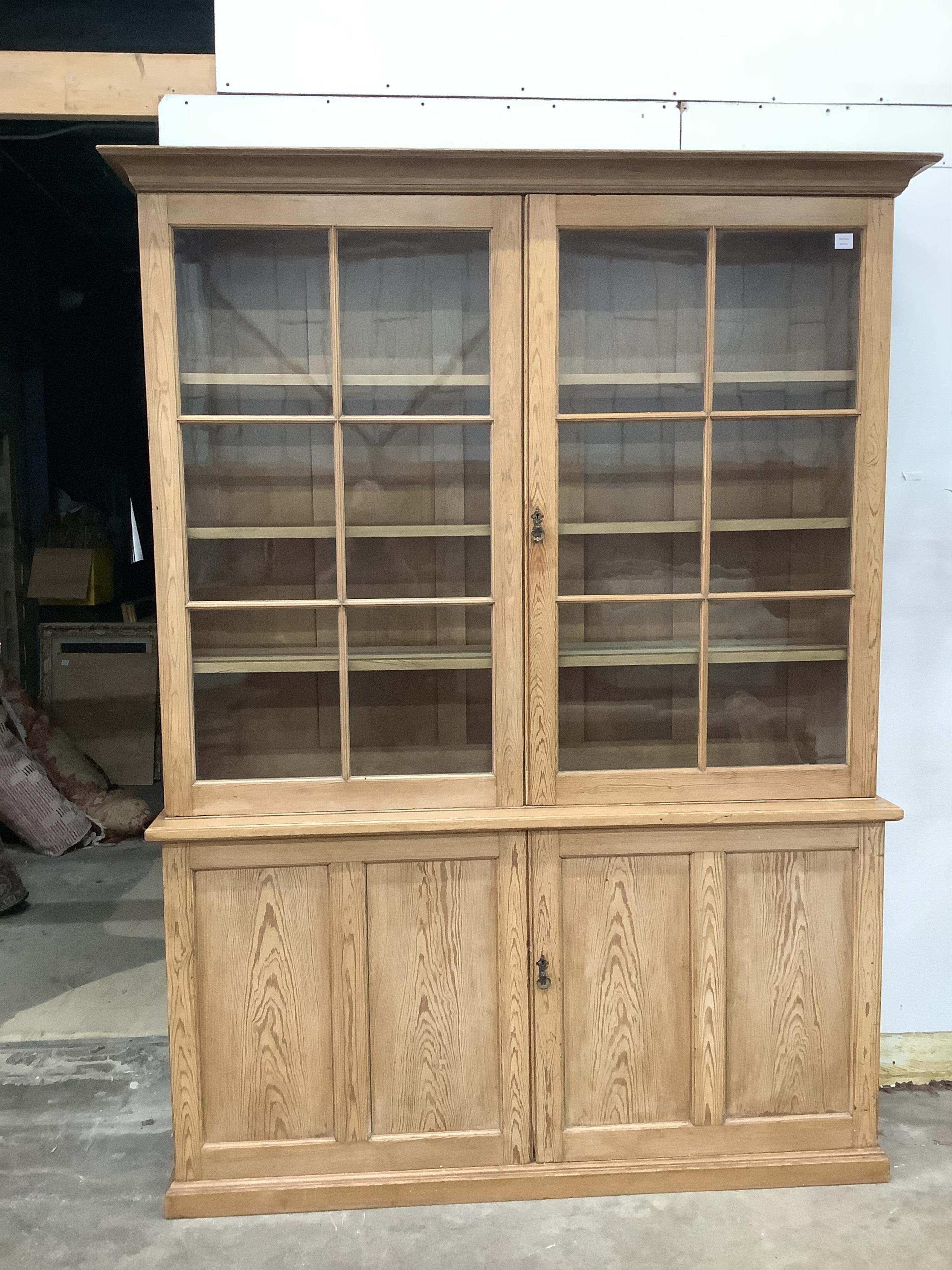A Victorian pitch pine bookcase / cupboard with compartmented panelled base, width 168cm, depth 42cm, height 231cm. Condition - good